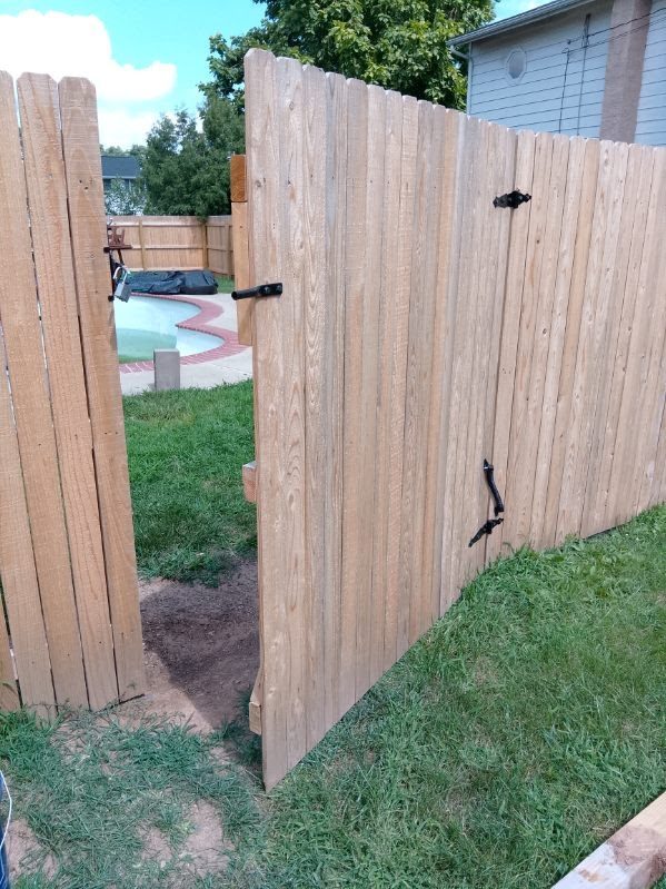 Wood privacy gate open on decorative strap hinges